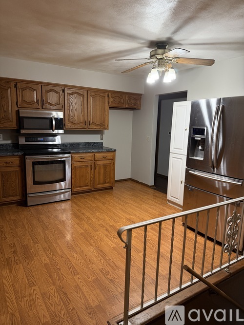A kitchen with wooden cabinets and a stainless steel refrigerator.