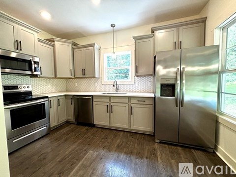 A kitchen with wooden floors and stainless steel appliances.