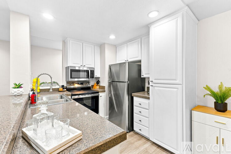 A kitchen with white cabinets and a granite countertop.