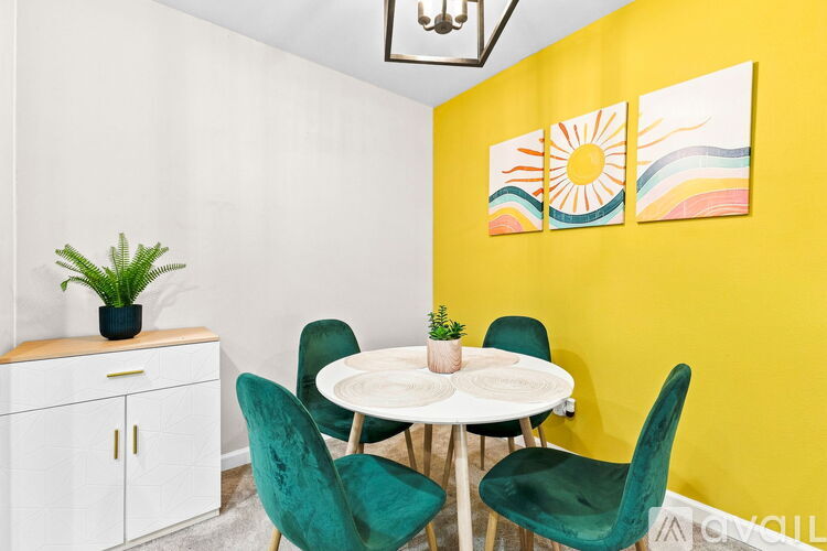 A dining room with a white table and green chairs.