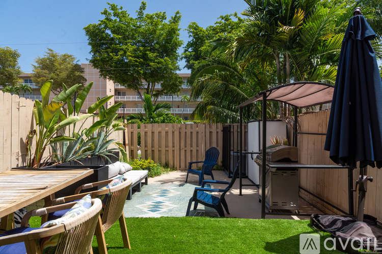 A backyard with a table, chairs, and a pool.