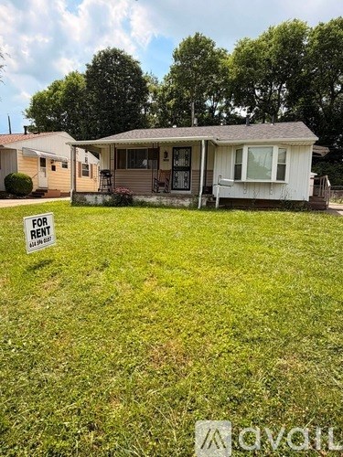 A house is for rent with a grassy area in front.