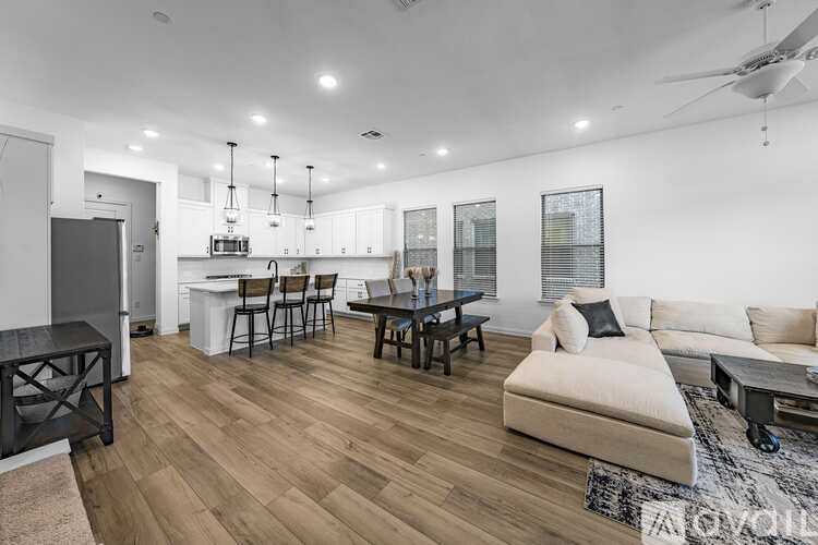 A modern living room with a white couch and wooden flooring.