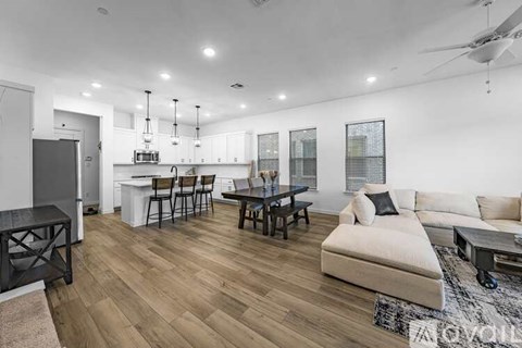 A modern living room with a white couch and wooden flooring.