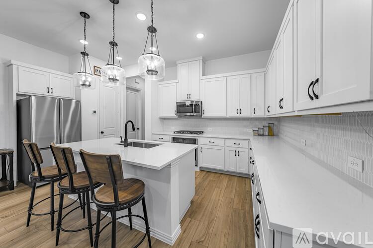 A modern kitchen with white cabinets and a central island.