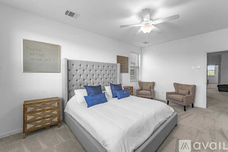 A bedroom with a large bed and a ceiling fan.