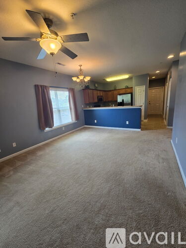 A room with a ceiling fan and a carpeted floor.