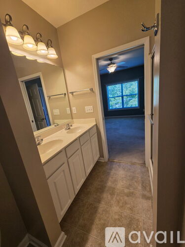 A bathroom with a sink, mirror, and light fixture.