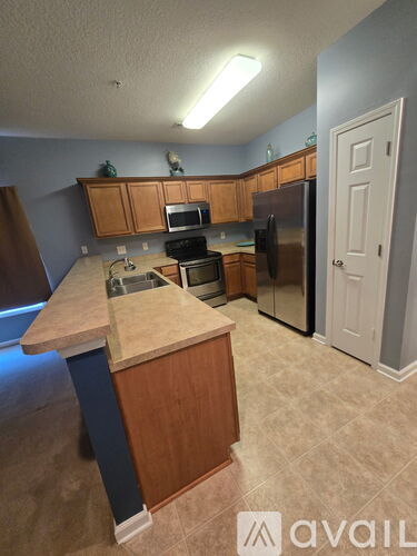 A kitchen with a sink, stove, and refrigerator.