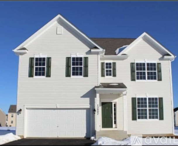 A white house with a green door and windows.