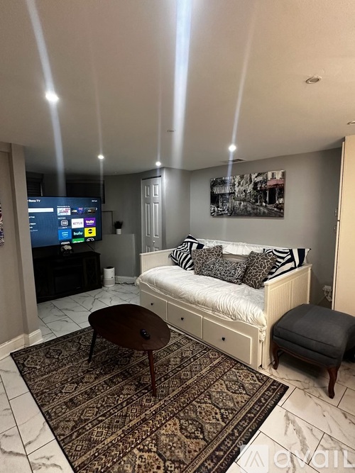 A bedroom with a bed, a table, and a TV.