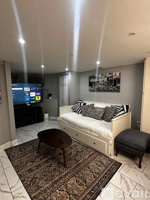 A bedroom with a bed, a table, and a TV.