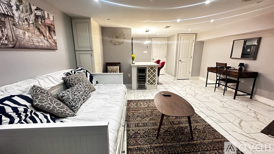 A living room with a white sofa and a zebra print pillow.