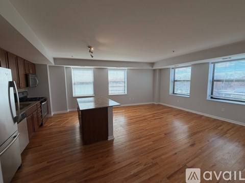 A kitchen with wooden floors and a large island in the middle.