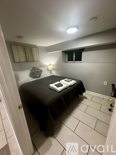 A bedroom with a bed, nightstand, and lamp.