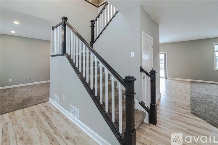 A spacious room with a staircase leading to the upper level.