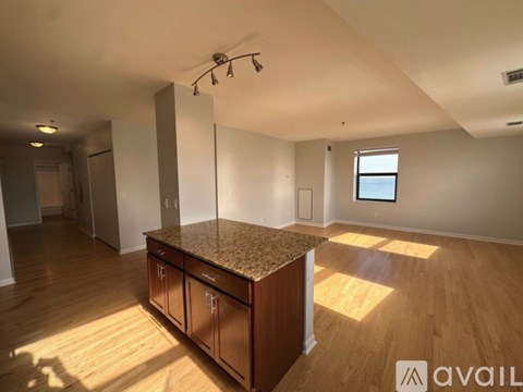 A spacious room with a granite countertop and wooden flooring.