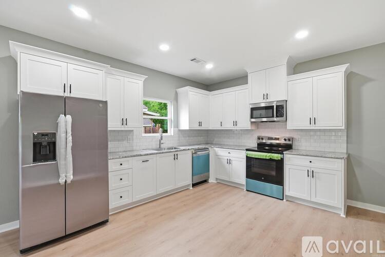 A kitchen with white cabinets and a stainless steel refrigerator.