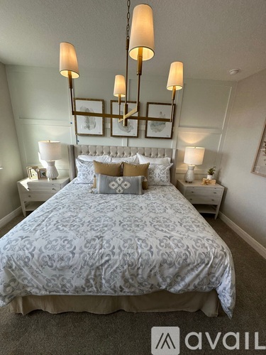 A bedroom with a large bed and a chandelier.