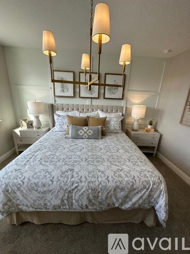 A bedroom with a large bed and a chandelier.