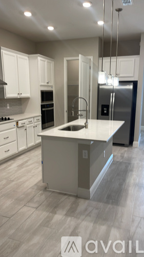 A modern kitchen with a large island and stainless steel appliances.