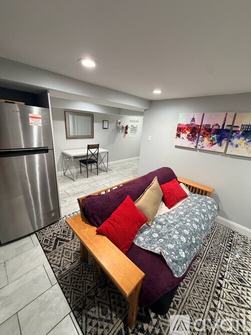 A living room with a couch and a refrigerator.