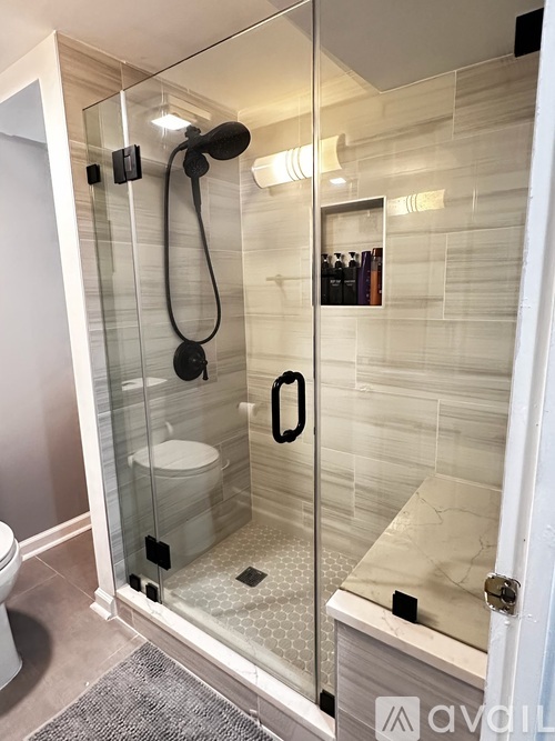 A bathroom with a glass shower door and a white toilet.