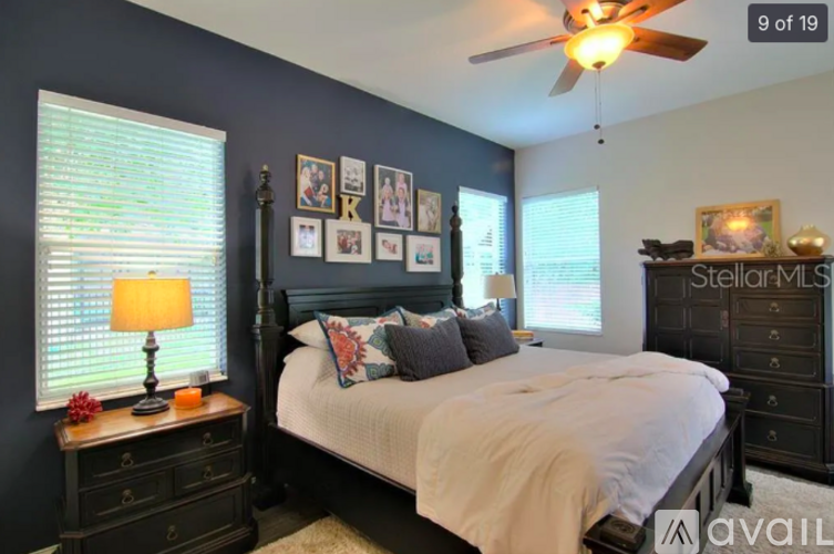 A bedroom with a bed, nightstand, and a ceiling fan.