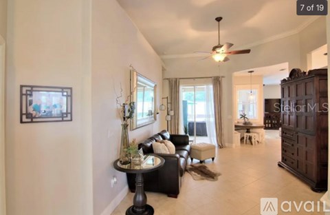 A living room with a sofa set, a coffee table, and a ceiling fan.