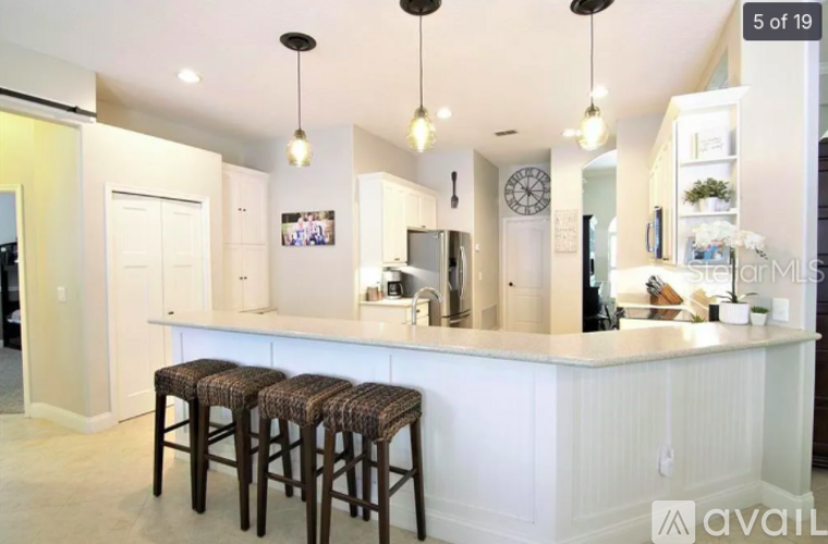 A kitchen with a bar stool in front of the counter.