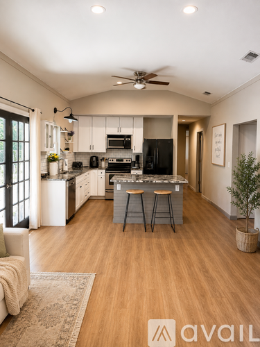 A modern kitchen with wooden floors and a large island.