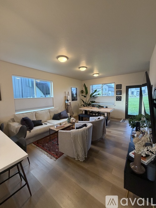 A living room with a couch, chairs, and a rug.