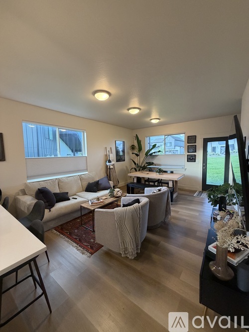 A living room with a couch, chairs, and a rug.