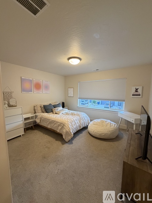 A bedroom with two beds and a window with a view of trees outside.