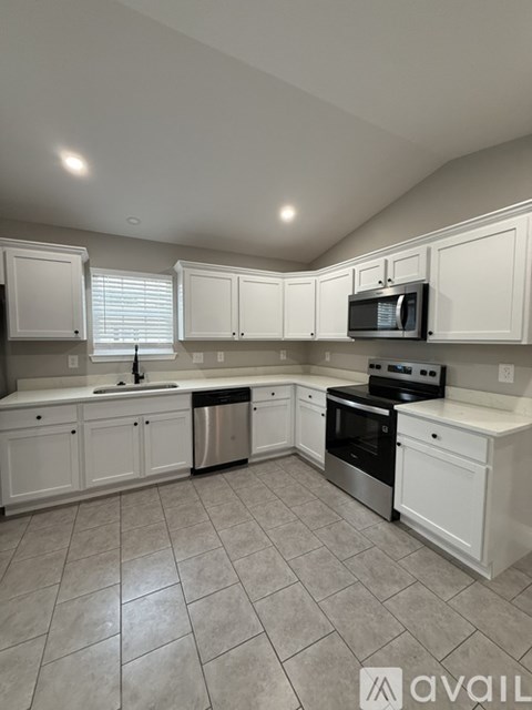 A kitchen with white cabinets and a stainless steel dishwasher.