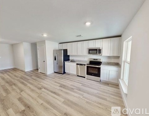 A kitchen with a refrigerator, oven, and microwave.