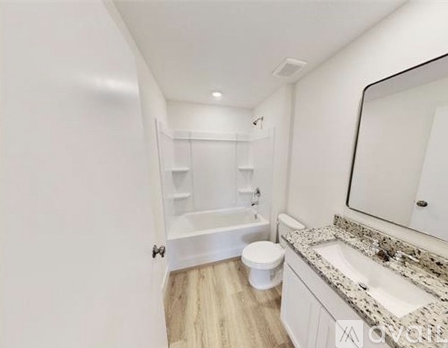 A white bathroom with a toilet, sink, and bathtub.