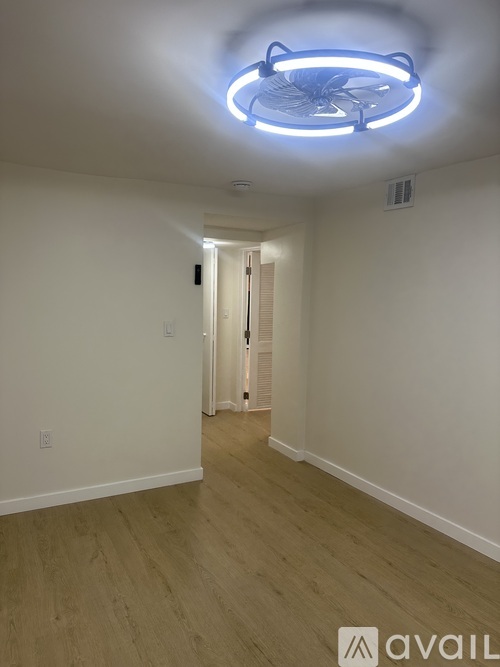 A room with a white wall and a wooden floor.