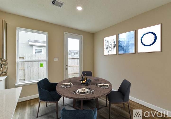 A dining room with a round table and chairs.