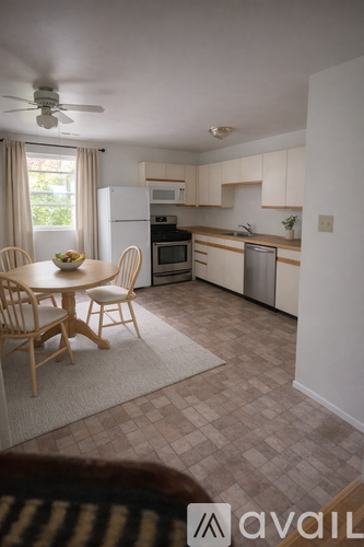 A kitchen with a table and chairs in front of a window.