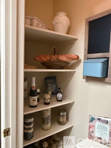 A kitchen pantry with a basket on the top shelf.