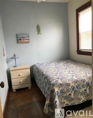A bedroom with a bed, dresser, and a painting on the wall.