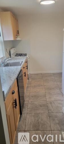 A kitchen with wooden cabinets and a tiled floor.