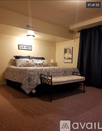 A bedroom with a bed and a sign that says "OUR NEST".