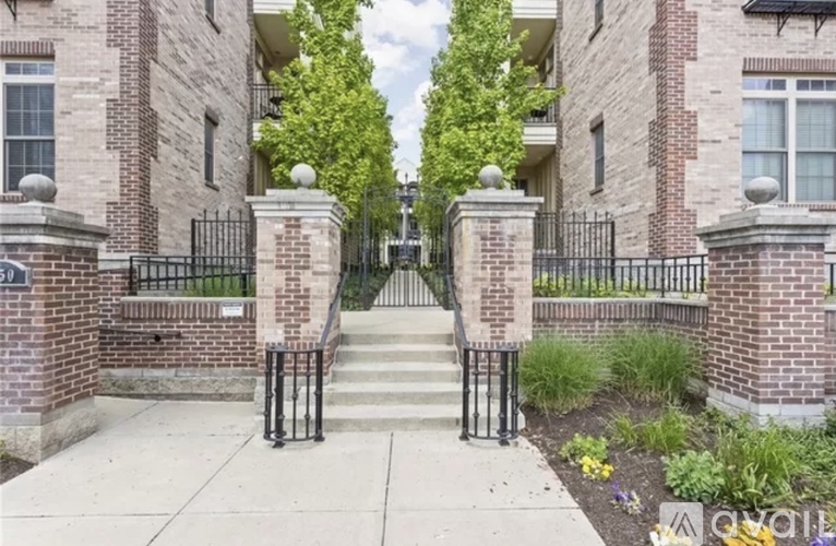 A brick building with a black iron fence and gate.