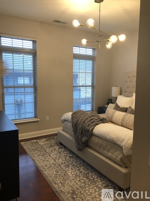 A bedroom with a large bed and a chandelier.