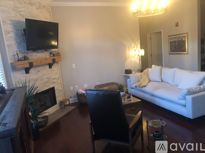 A living room with a white couch and a fireplace.