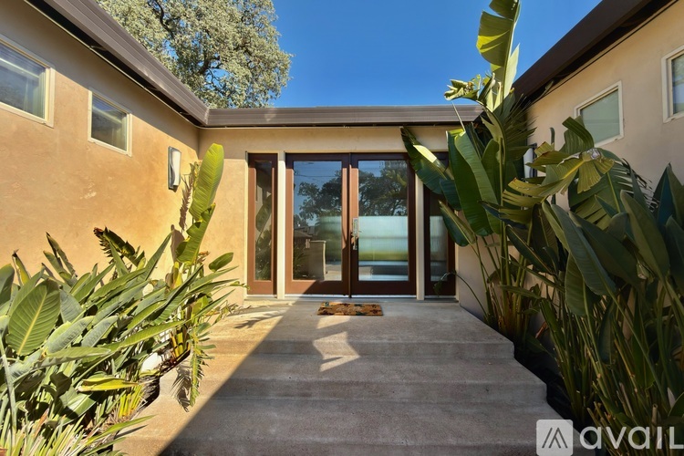 A house entrance with a glass door and a carpet leading to it.