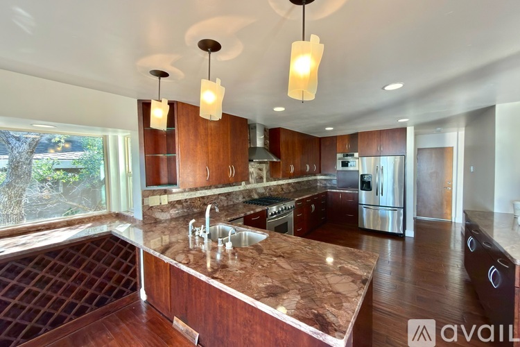 A kitchen with wooden cabinets and a marble countertop.