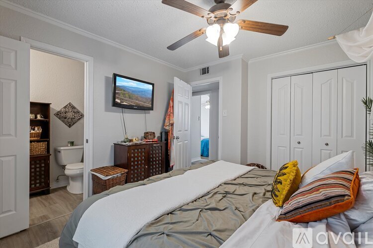 A bedroom with a large bed and a ceiling fan.